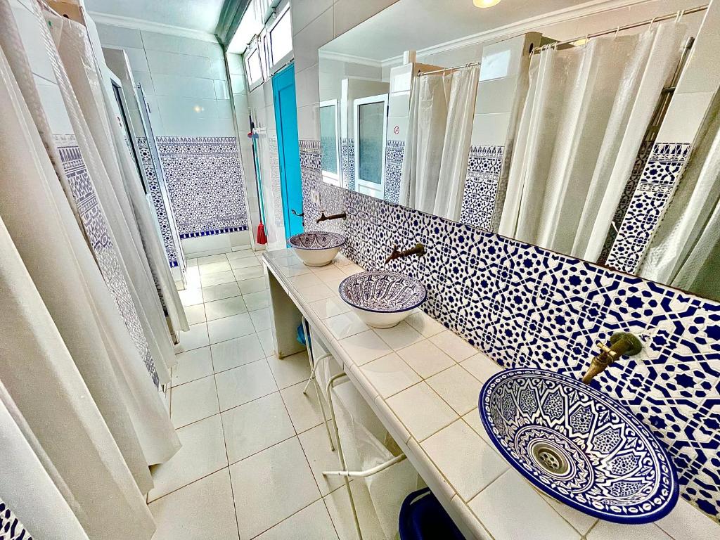 a bathroom with two sinks and a large mirror at Riad Darna in Tetouan