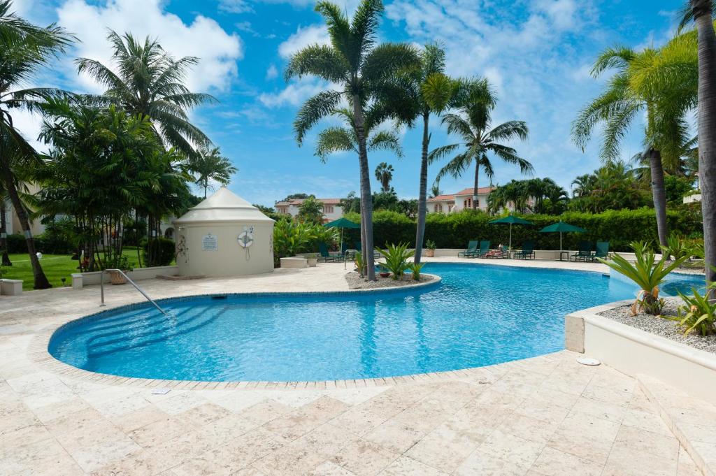 a pool at a resort with palm trees at Paradise Palms Sugar Hill in Saint James