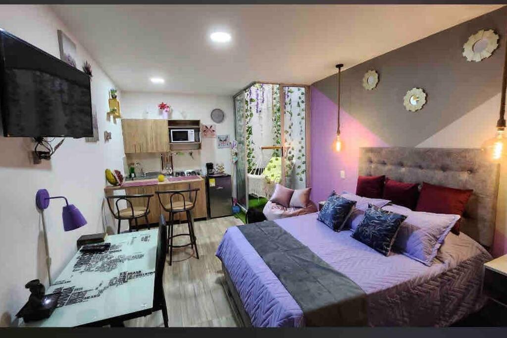 1 dormitorio con 1 cama grande y cocina en ~•handsome apartment for tourists in Medellin, en Medellín