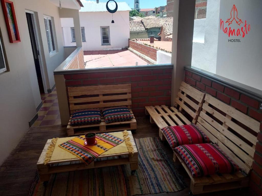 two benches sitting on a balcony with a window at Namaste Hostel in Tarija