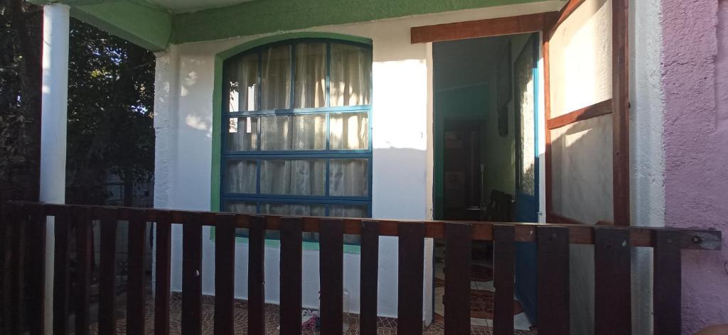 un porche de una casa con una puerta y una valla en El Remanso, en Durazno