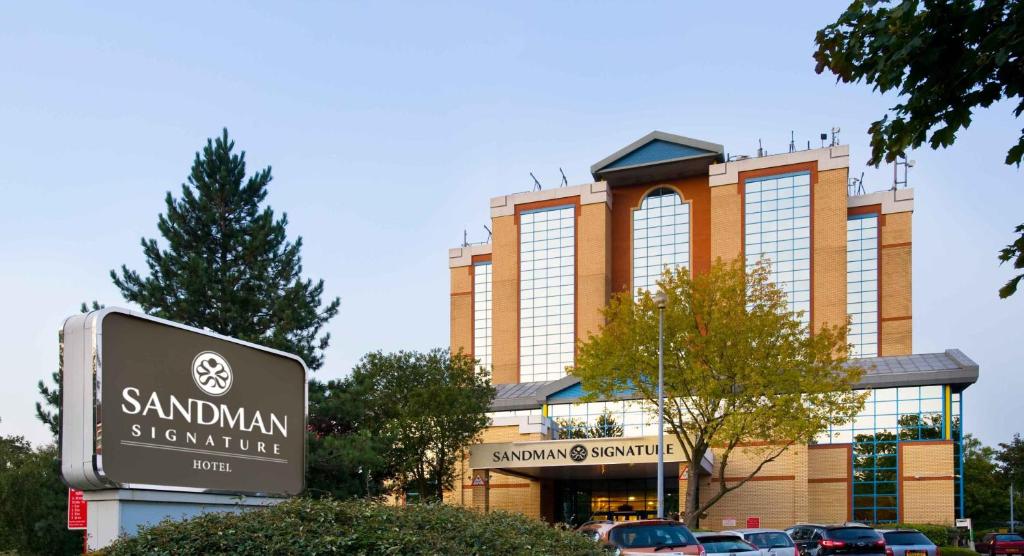 クローリーにあるSandman Signature London Gatwick Hotelの看板が目の前にある大きな建物