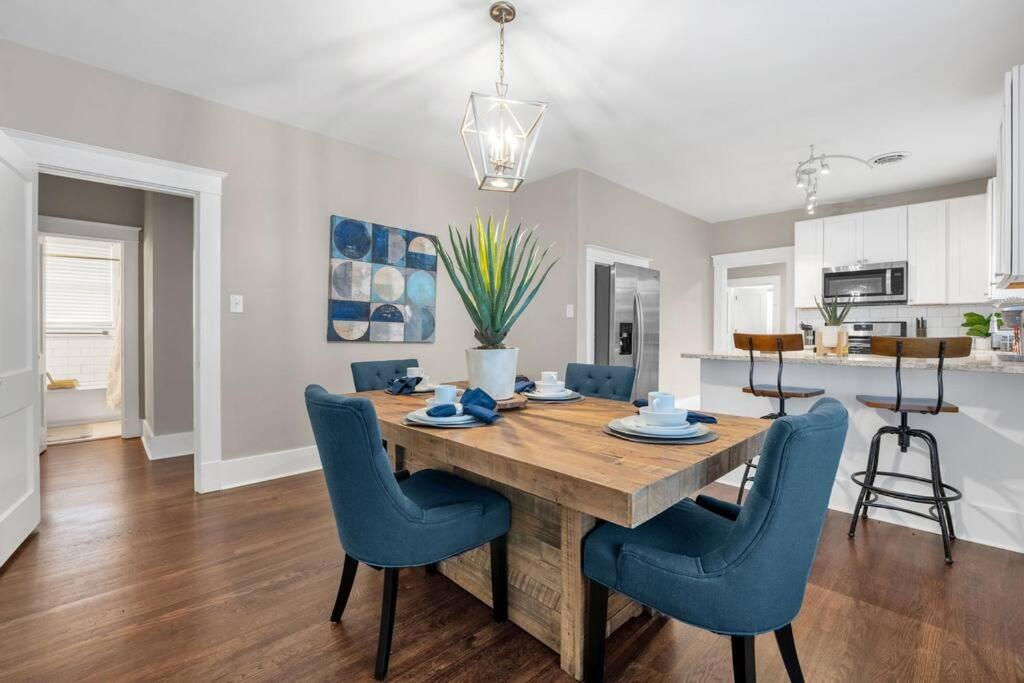 cocina y comedor con mesa de madera y sillas azules en Contemporary Cottage near zoo and Rhodes college en Memphis