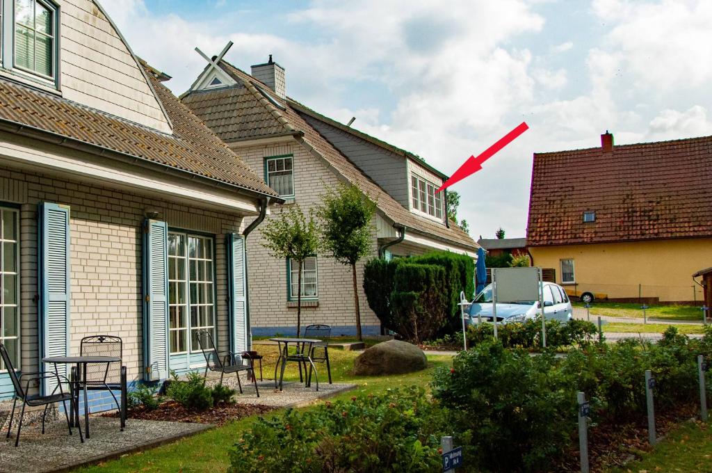 a house with a red arrow pointing into a yard at App Seeblick in ruhiger Lage in Seedorf in Seedorf