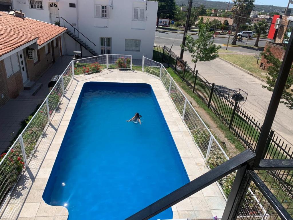 a person is swimming in a swimming pool at Cabañas San Gabriel Carlos Paz in Villa Carlos Paz