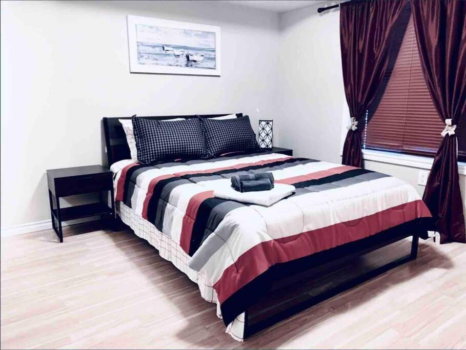 a bedroom with a large bed in a room at 2 BDRM A/C Condo w/Ensuite Laundry + Free Parking in Edmonton