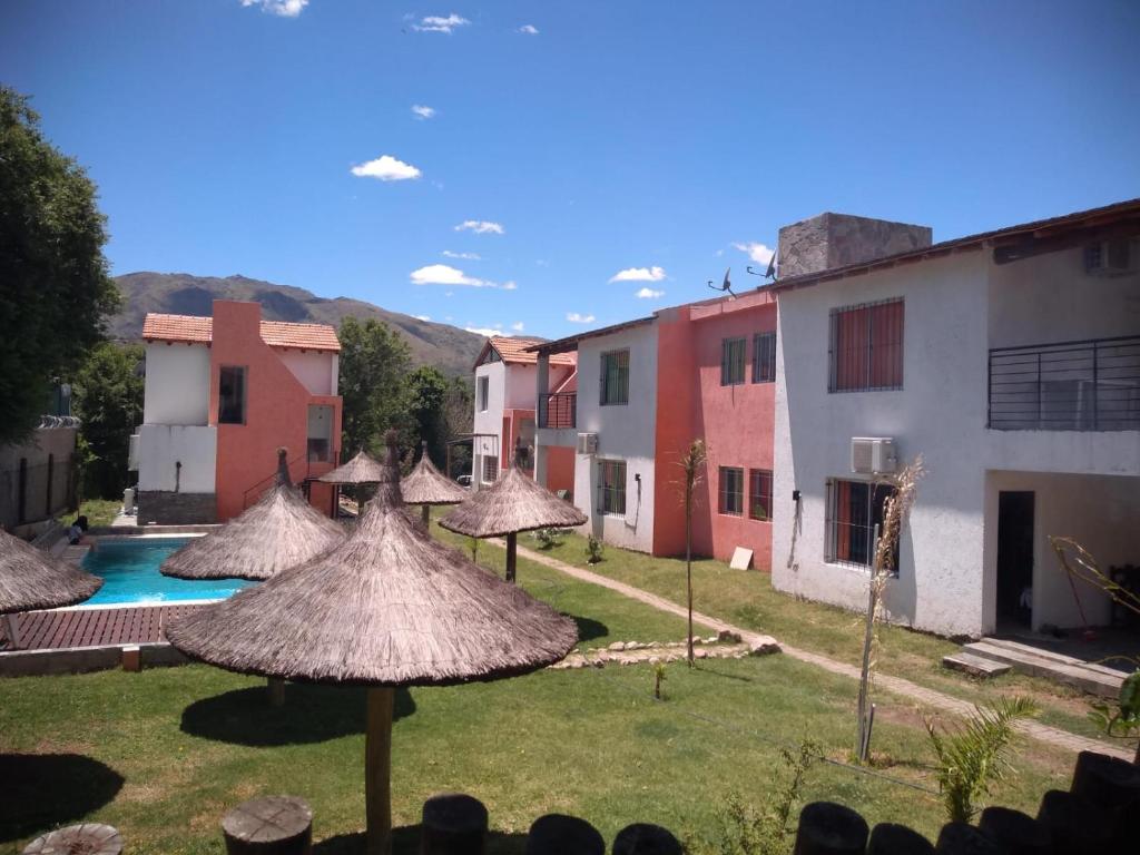 a group of umbrellas in a yard with a pool at Cabañas El Doral in Potrero de los Funes