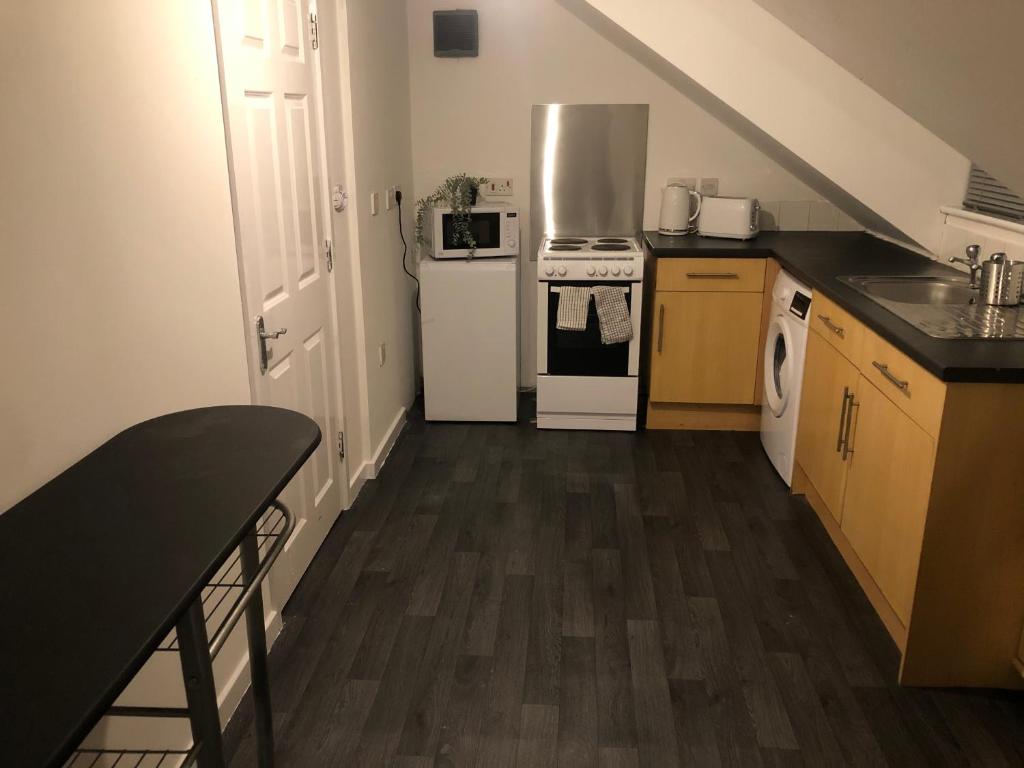 a kitchen with white appliances and wooden floors at 1 bedroom flat Oakfield Road in Bristol