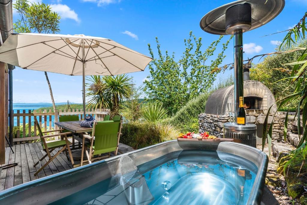 a hot tub on a patio with an umbrella at Wai Marino - Taupo in Taupo