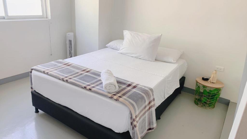 a bedroom with a bed with white sheets and pillows at Aloja-T en Apartamento amoblado 3 Ciudad Bolivar in Ciudad Bolívar