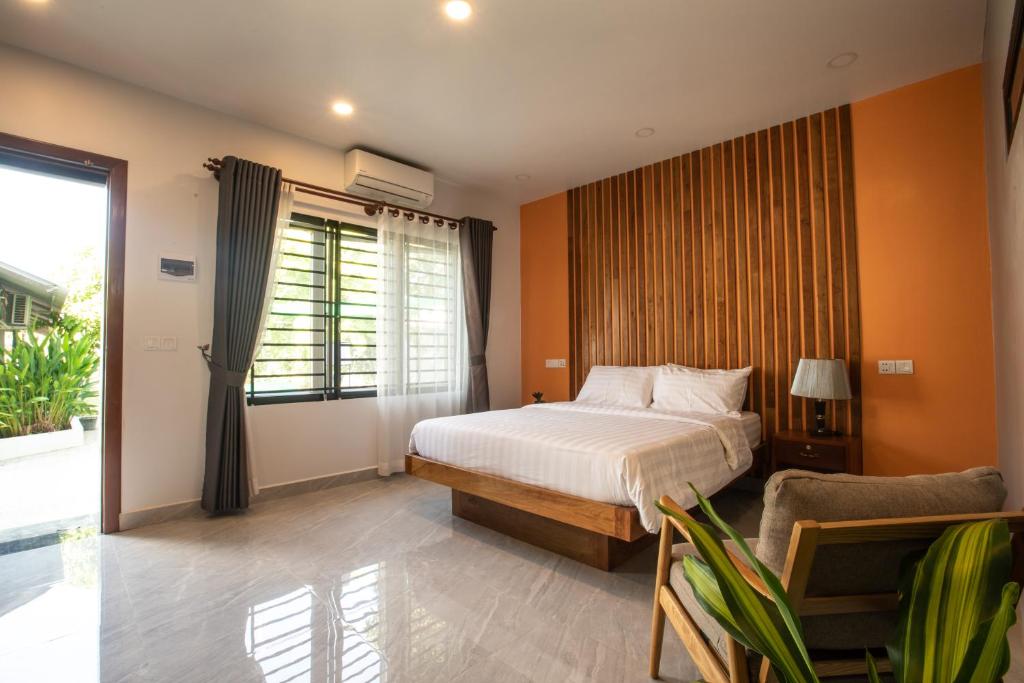 ein Schlafzimmer mit einem Bett und einem großen Fenster in der Unterkunft Siem Reap Homesteading in Siem Reap
