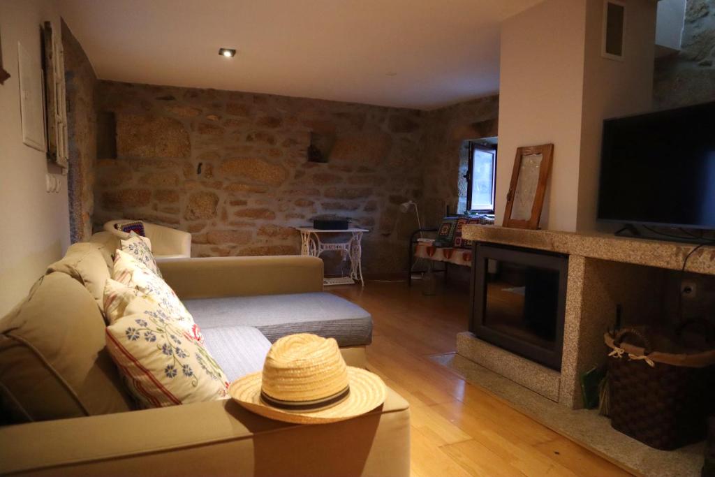 a living room with a couch and a fireplace at Casa do Soito. in Avelãs de Ambom