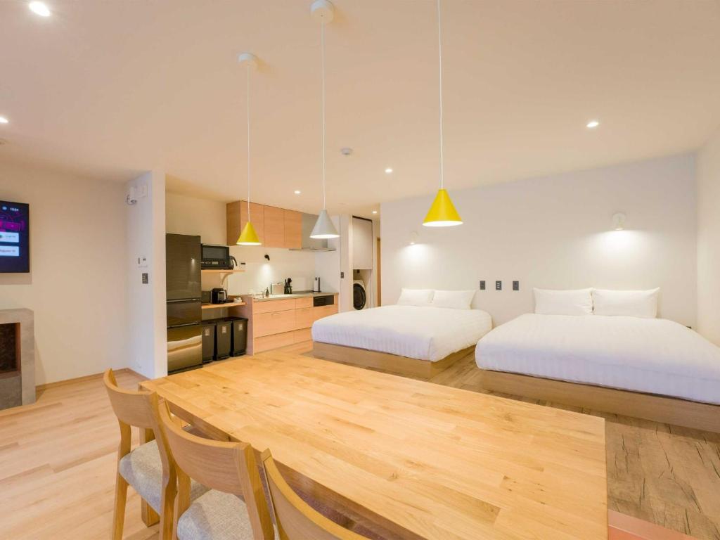 two beds in a room with a table and a kitchen at Rakuten STAY VILLA Nasu Standard Room Capacity of 8 persons in Nasu-yumoto