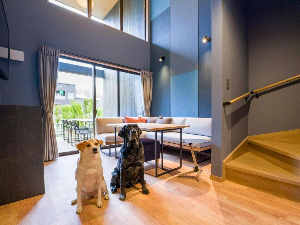 zwei Hunde in einem Zimmer mit einem Tisch in der Unterkunft Rakuten STAY VILLA Nasu Villa Type pet allowed Capacity of 10 persons in Nasu-yumoto