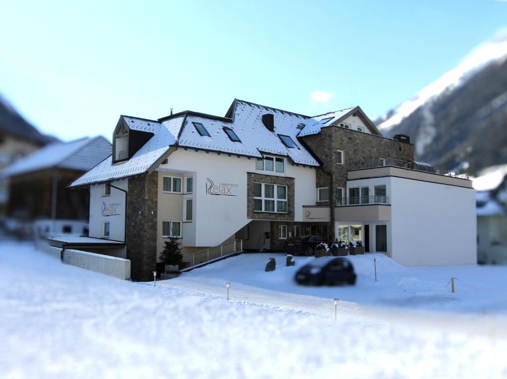 a building with snow on the roof in the snow at Relax Apartments in Ischgl