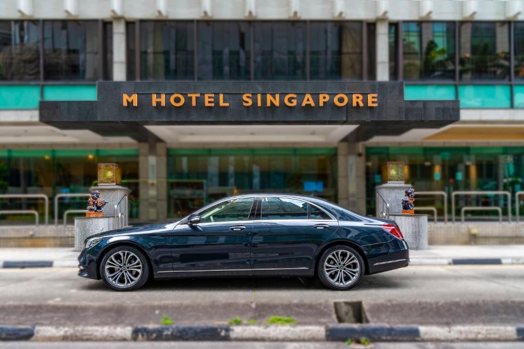 新加坡的住宿－M Hotel Singapore City Centre，一辆停在一家新加坡酒店前面的蓝色汽车