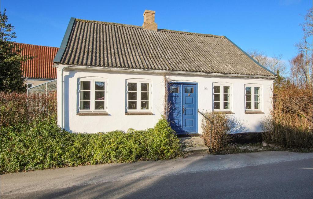 a small white house with a blue door at Awesome Home In Sams With Wifi in Ballen