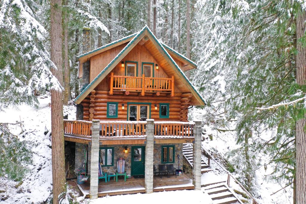 a log cabin in the woods in the snow at ArborMyst in Glacier