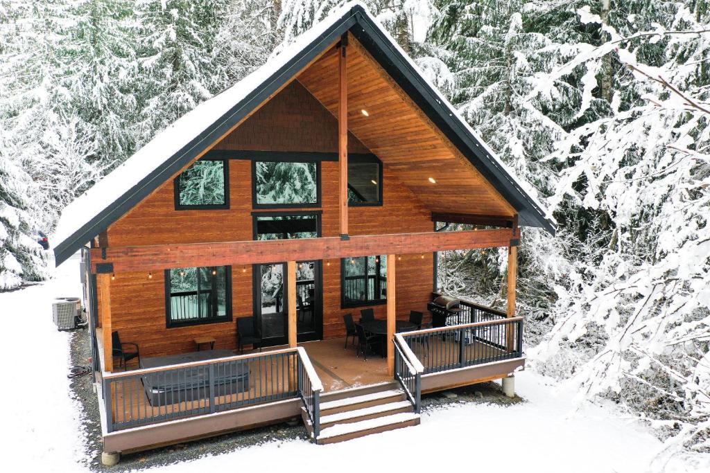 a log cabin in the snow with snow covered trees at Cottonwood Cabin in Glacier