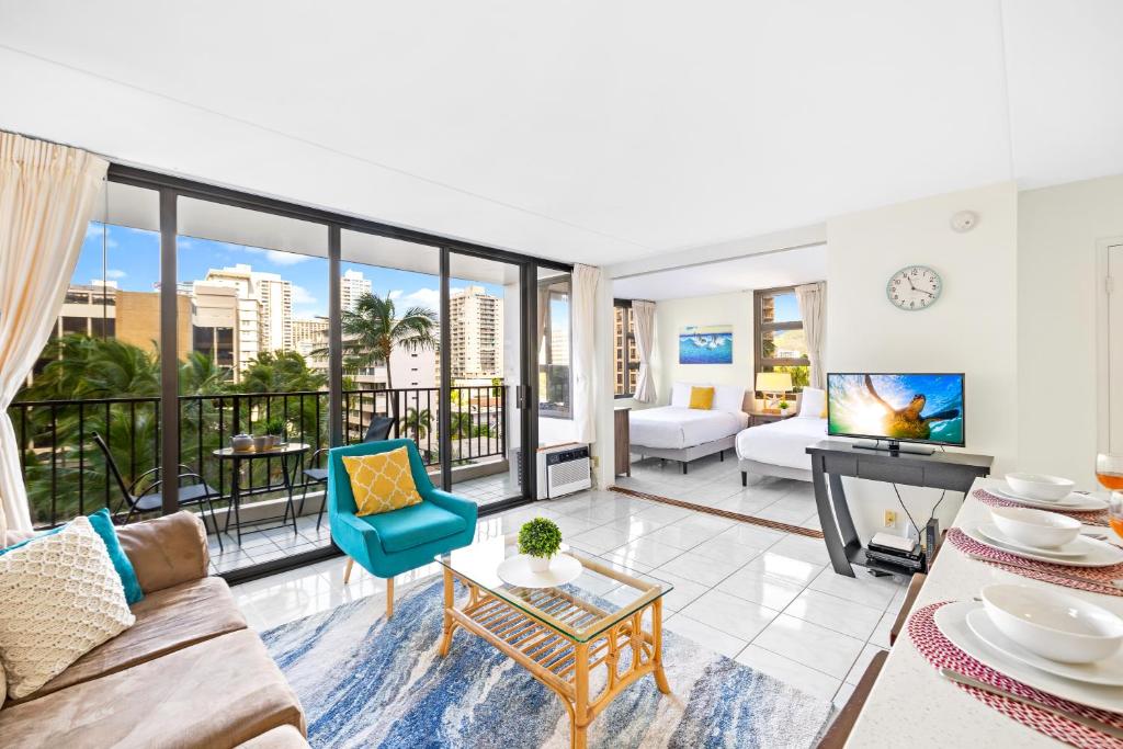 a living room with a couch and a tv at Waikiki Banyan Oasis with Partial Ocean View, 1-Block to Beach, Free Parking in Honolulu