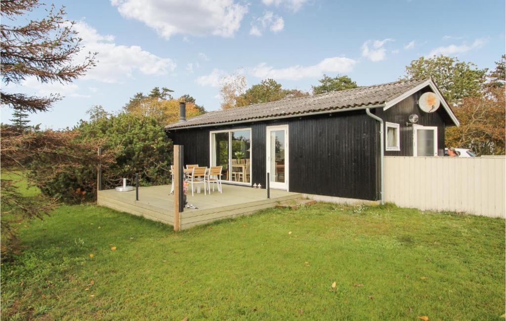 a black house with a deck in a yard at Beautiful Home In Sams With Kitchen in Kolby Kås