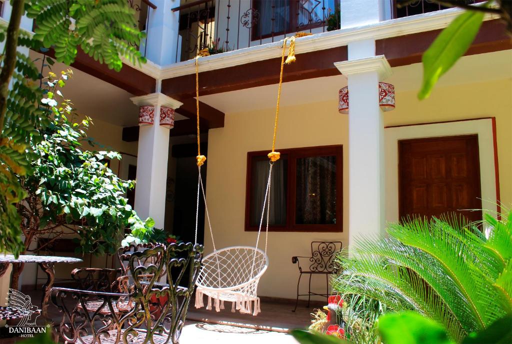 a porch of a house with chairs and a swing at Hotel Danibaan in Oaxaca City