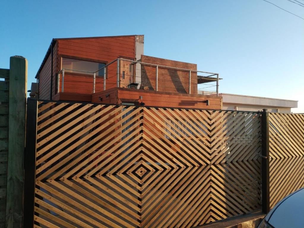 a house on top of a wooden fence at Hermosa casa a pasos de la playa, excelente vista. in Pichilemu