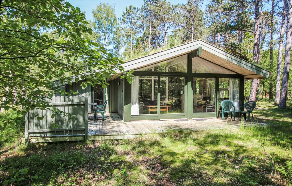 Nice Home In Sams With Kitchen في Nordby: منزل به شرفة تطل على الغابة