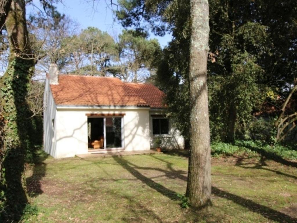 una pequeña casa blanca en medio de un patio en Maison familiale près plage St Brevin, animaux admis, parking privé - FR-1-364-40, en Saint-Brevin-les-Pins