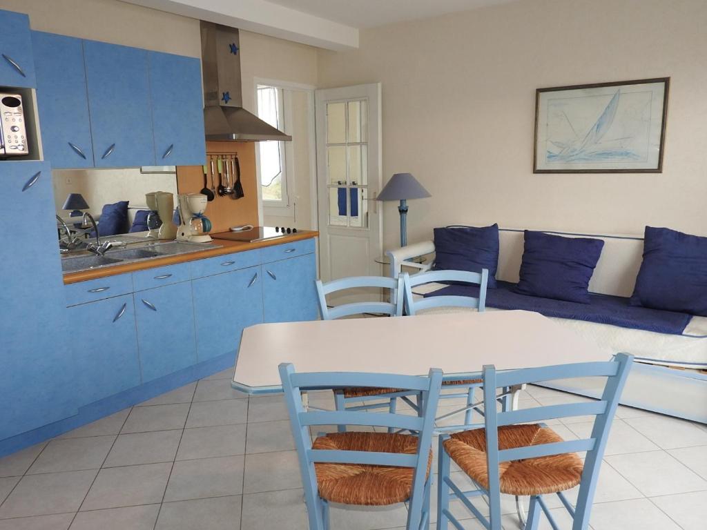 レ・サ​​ーブル・ドロンヌにあるAppartement Les Sables-d'Olonne, 2 pièces, 3 personnes - FR-1-92-779のキッチン(青いキャビネット、テーブル、椅子付)