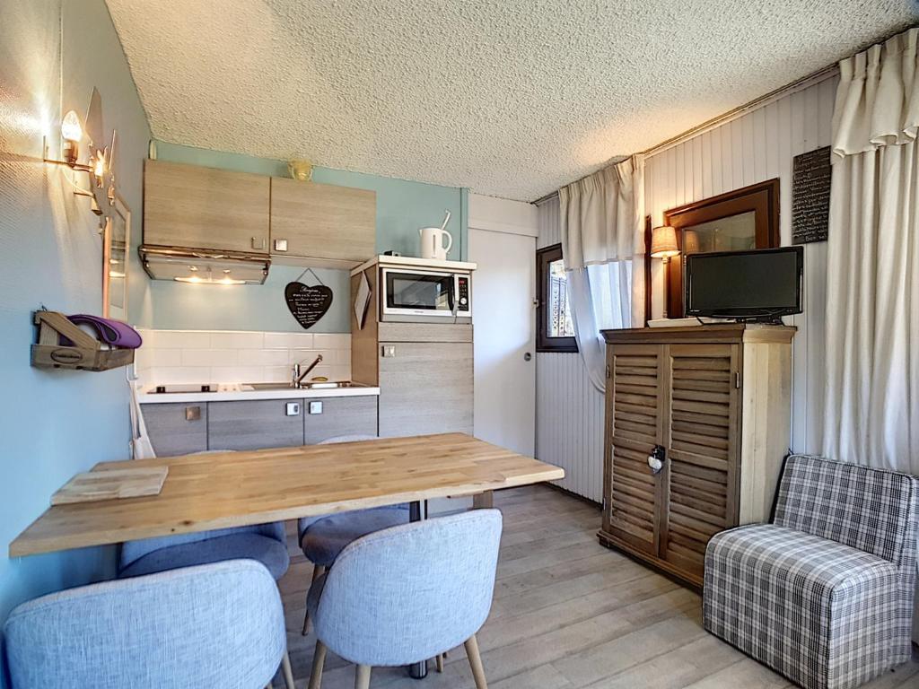 a small kitchen with a wooden table and chairs at Appartement Les Gets, 2 pièces, 4 personnes - FR-1-454-26 in Les Gets