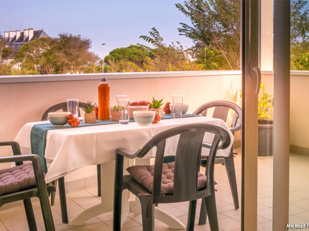 - une table sur un balcon avec une table et des chaises dans l'établissement Appartement moderne 3 pièces avec balcon, ascenseur, proche plages et commerces, parking inclus - FR-1-349-64, à Ploemeur