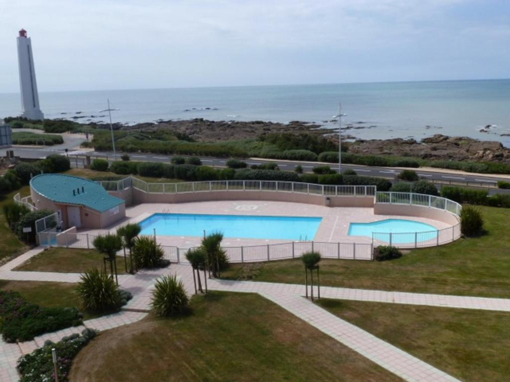 une piscine avec l'océan en arrière-plan dans l'établissement Studio avec Piscine, Parking et Balcon aux Sables-d'Olonne - FR-1-197-380, à Les Sables-dʼOlonne