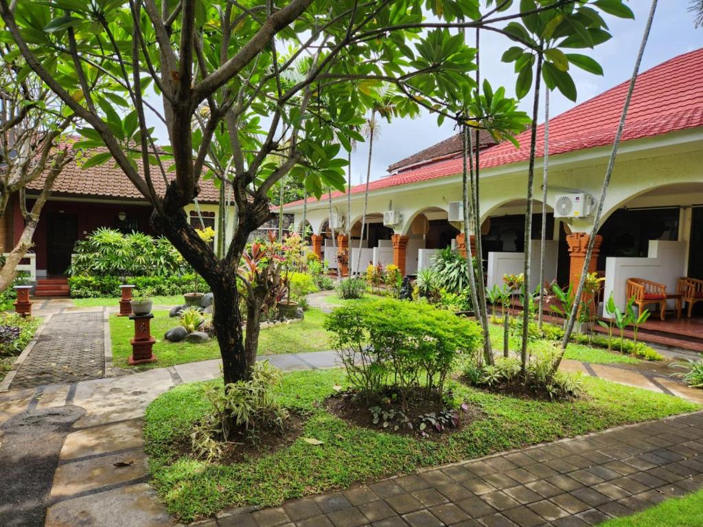 einen Innenhof eines Gebäudes mit einem Baum in der Unterkunft Ramayana Hotel in Sanur