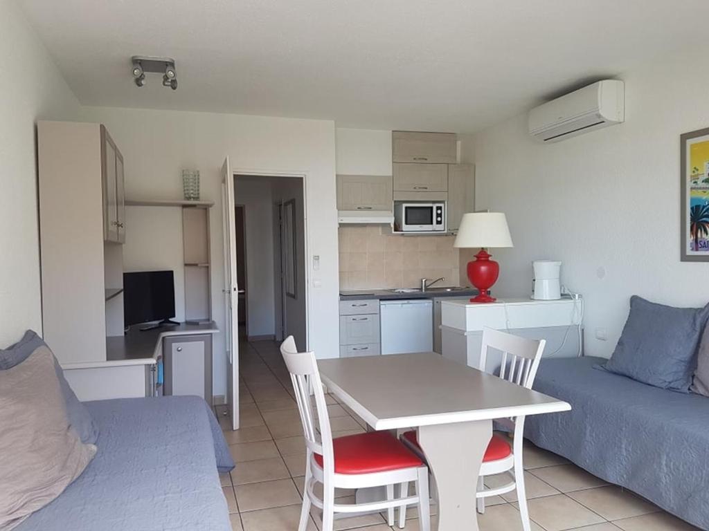 une cuisine et un salon avec une table et des chaises dans l'établissement Appartement 2 Pièces avec Balcon, Climatisé, Proche Plage et Centre-Ville - FR-1-466A-2, à Saint-Raphaël