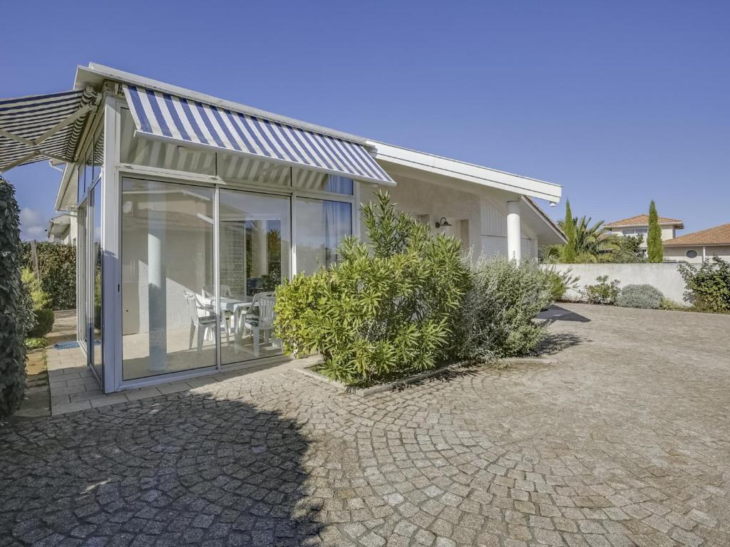 ein Haus mit Glasschiebetüren und einer Terrasse in der Unterkunft Villa 2 chambres proche plage, jardin, véranda, clim, wifi à Biscarrosse - FR-1-521-19 in Biscarrosse-Plage