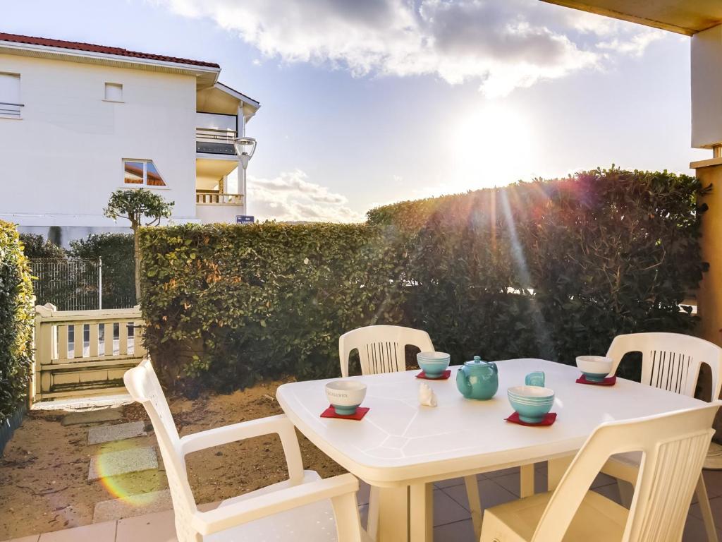 une table blanche et des chaises sur une terrasse dans l'établissement Appartement T3 avec Terrasse - à 50m de la Plage de Biscarrosse, Parking Privé Inclus - FR-1-521-15, à Biscarrosse-Plage