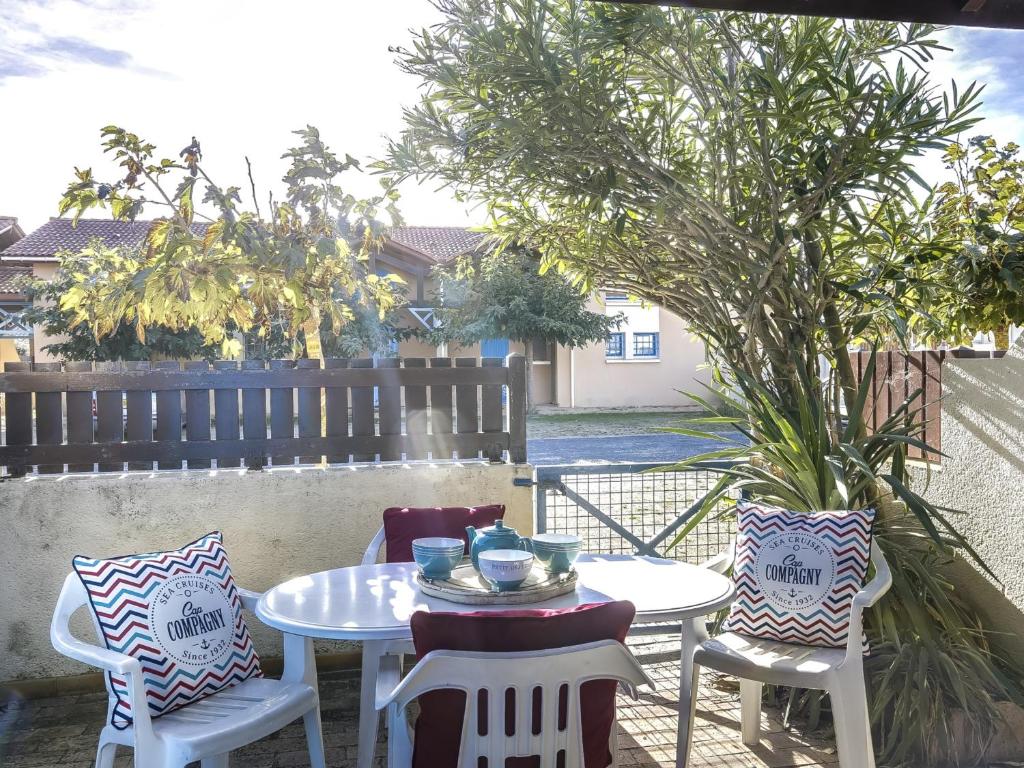 une table et des chaises assises sur une terrasse dans l'établissement Maison T2 mezzanine près de l'océan - 5/6 personnes - terrasse et parking privé - 40600 Biscarrosse - FR-1-521-23, à Biscarrosse-Plage