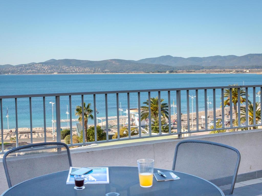 - un balcon avec des tables et des chaises offrant une vue sur la plage dans l'établissement Appartement climatisé avec terrasse, à 50m de la plage et proche commerces, gare et centre-ville. - FR-1-466A-9, à Saint-Raphaël