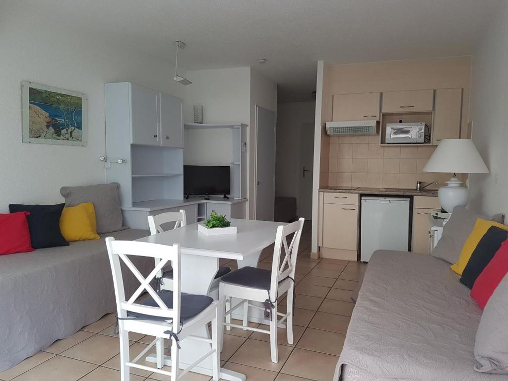 eine Küche und ein Wohnzimmer mit einem Tisch und Stühlen in der Unterkunft Studio Saint-Raphaël, 1 pièce, 3 personnes - FR-1-466A-7 in Saint-Raphaël