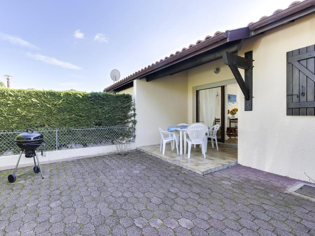d'une terrasse avec un grill, une table et des chaises. dans l'établissement Maison T2 cabine à Biscarrosse Plage, proche des commerces et de la mer - FR-1-521-90, à Biscarrosse-Plage