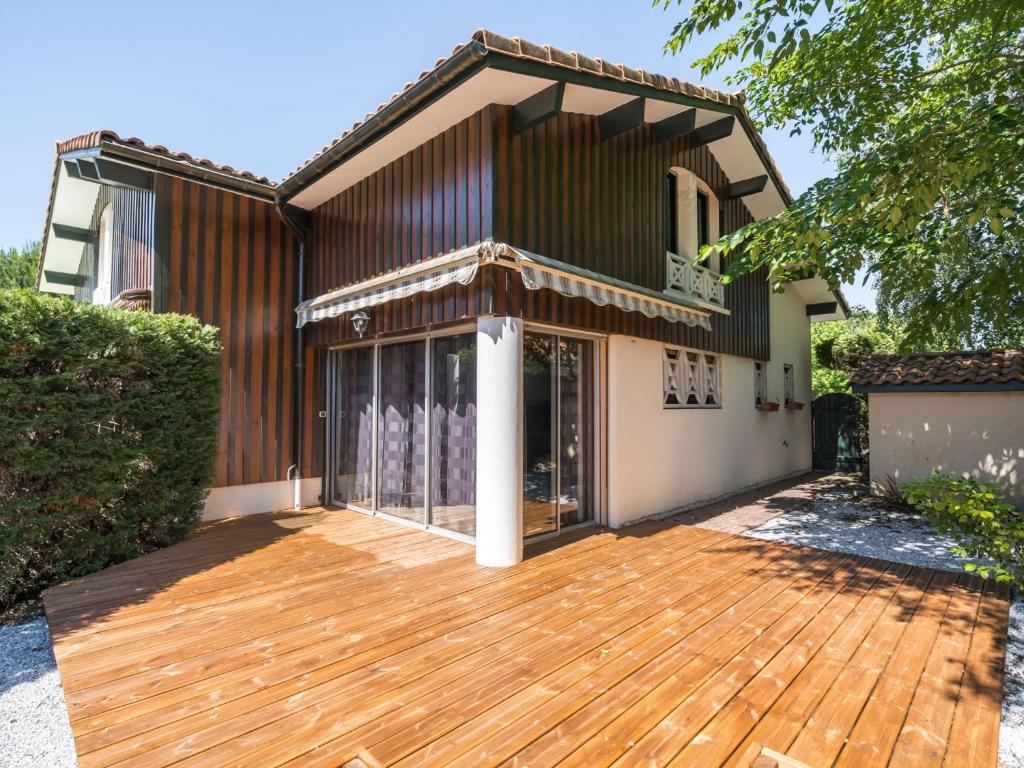 a wooden deck in front of a house at Maison T3, jardinet clos, proche lac de Biscarrosse, 4/5 pers, au calme et parking inclus - FR-1-521-33 in Biscarrosse