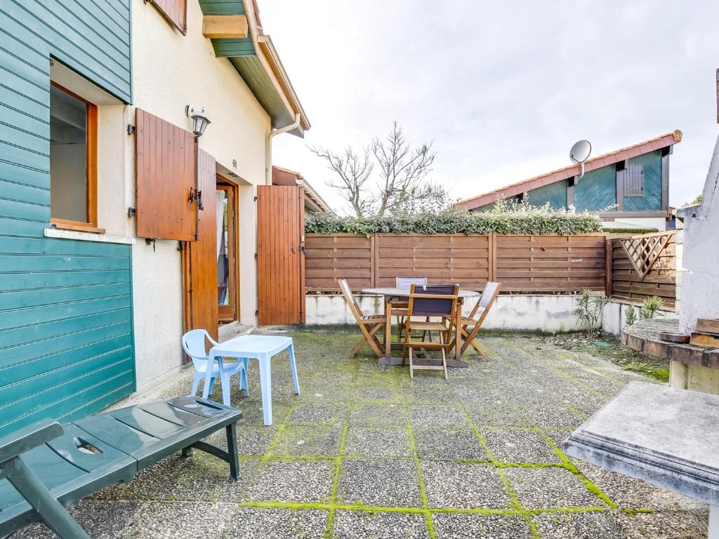 un patio avec une table et des chaises et une clôture dans l'établissement Biscarrosse Plage, maison T3 avec jardin, animaux admis, à 400m de la mer! - FR-1-521-107, à Biscarrosse-Plage