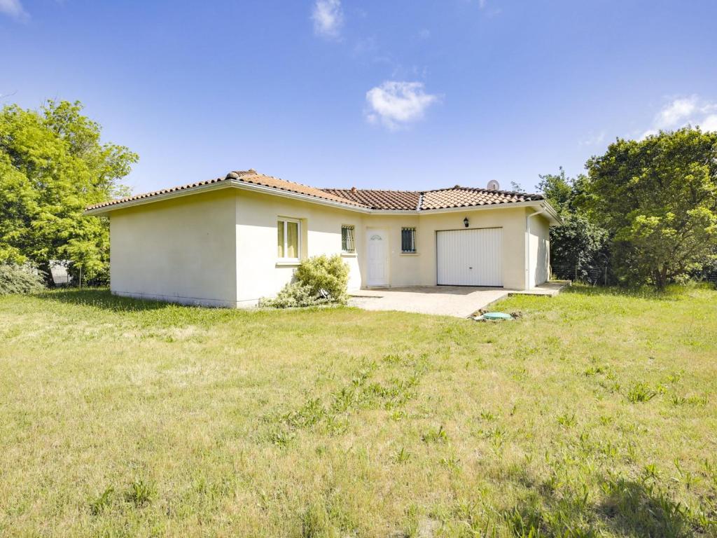 une petite maison blanche avec une cour gazonnée dans l'établissement Maison Moderne à Biscarrosse Bourg, 4 Pers., Près du Centre-Ville, Grand Terrain - FR-1-521-131, à Biscarrosse
