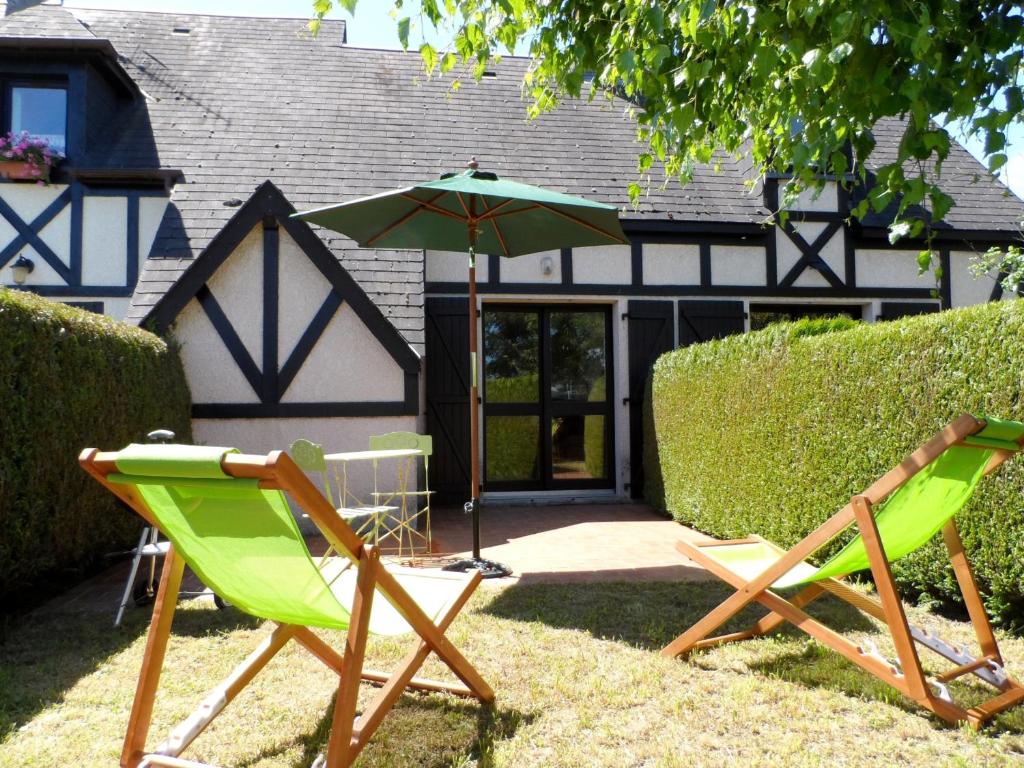 2 chaises longues et un parasol dans la cour dans l'établissement Charmant Cottage Normand avec Jardin, Proche Hippodrome, Piscine Chauffée et Tennis, Parking Privé - FR-1-487-288, à Cabourg