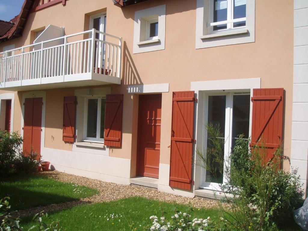 a house with red doors and a balcony at Cottage 3 pièces à Dives-sur-Mer, jardin privé, proche Port Guillaume, piscine, animaux acceptés - FR-1-487-301 in Dives-sur-Mer