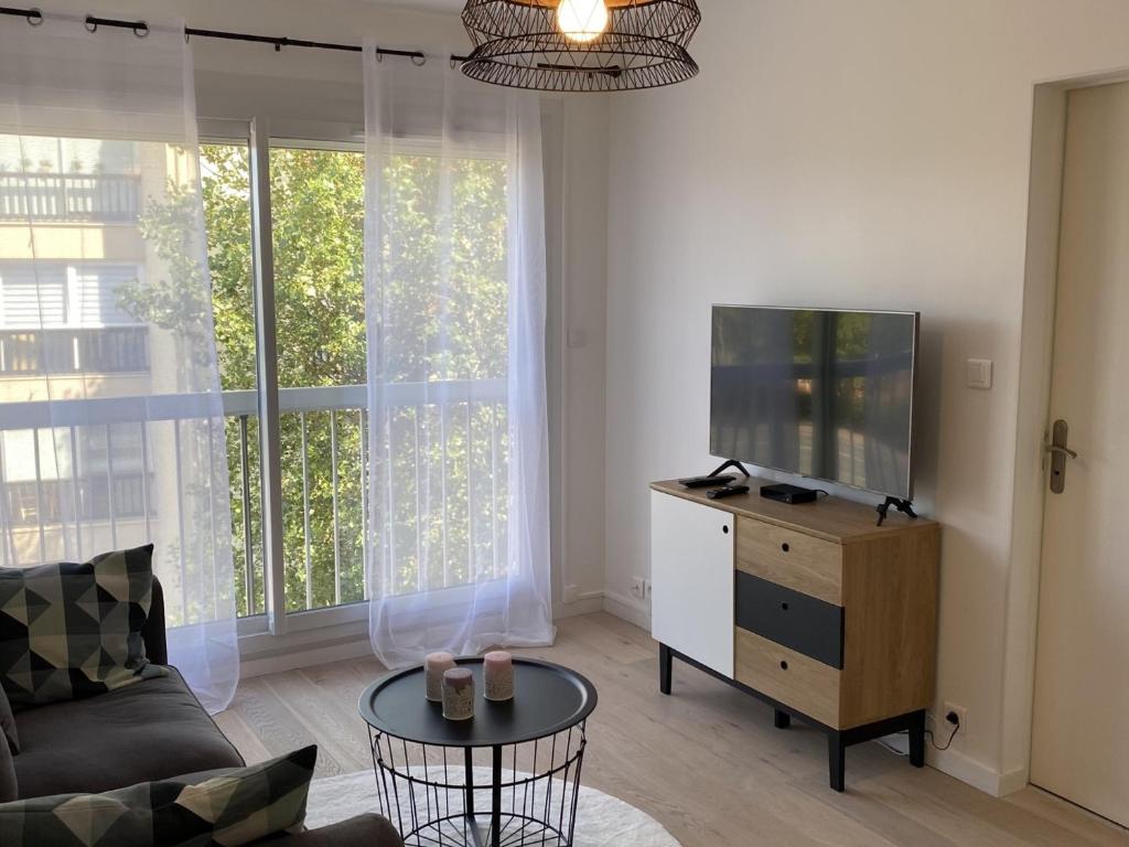 - un salon avec un canapé et une télévision sur une commode dans l'établissement Charmant 2 pièces avec parking et ascenseur, proche centre-ville de Cabourg - FR-1-487-323, à Cabourg