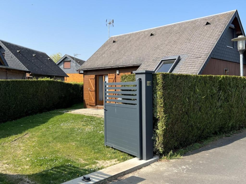 a house with a gate in front of a fence at Chalet Cabourg, 4 pièces, 6 personnes - FR-1-487-325 in Cabourg