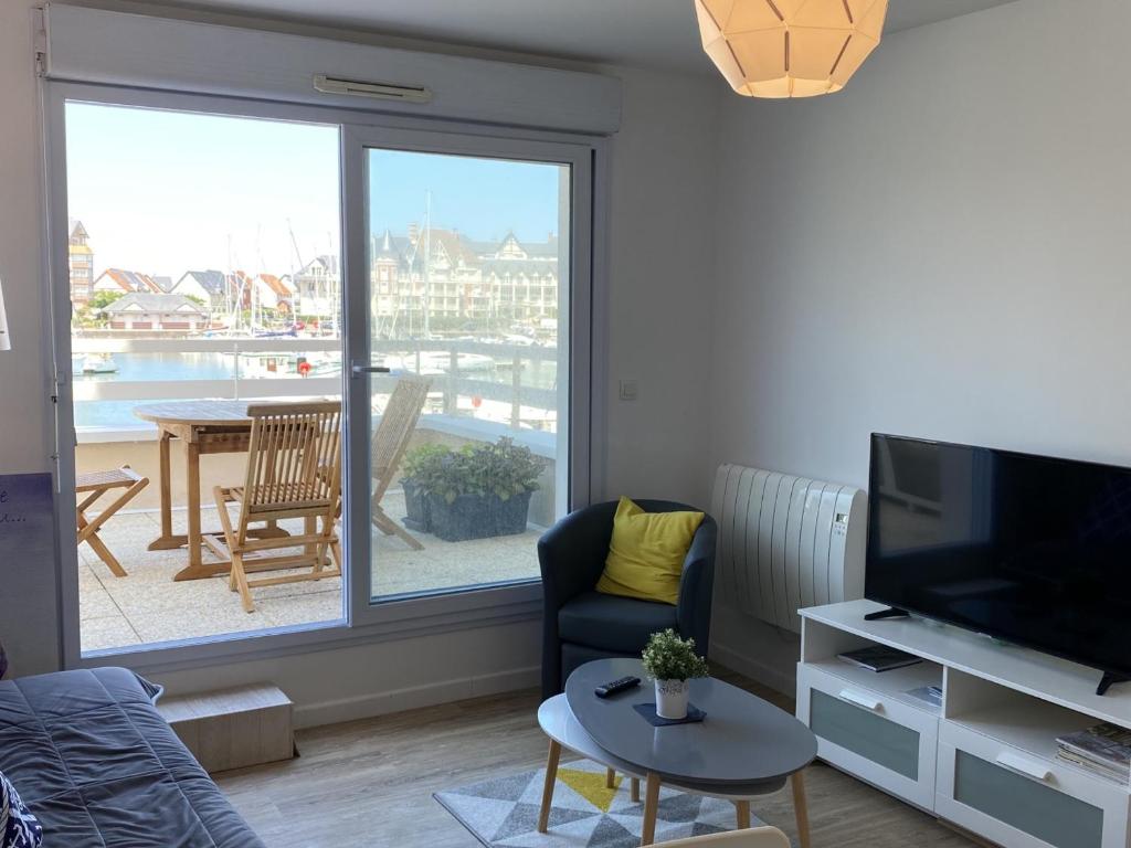 a living room with a view of a balcony at Bel Appartement Duplex 4 pièces avec Vue sur Port et Terrasse - FR-1-487-314 in Dives-sur-Mer