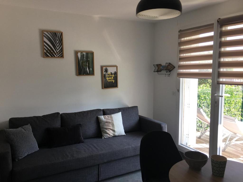 un salon avec un canapé bleu et une table dans l'établissement Studio Front de Mer avec Terrasse et Accès Direct Plage à Merville-Franceville - FR-1-487-329, à Merville-Franceville-Plage